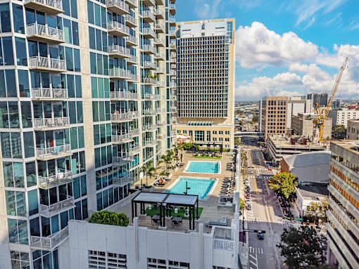 A view of a cityscape with a pool in the foreground.