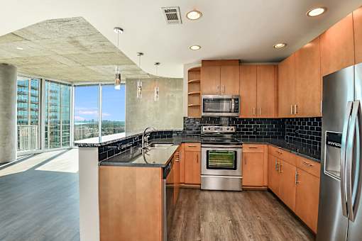 A modern kitchen with wooden cabinets and stainless steel appliances. at Element, Tampa, Florida