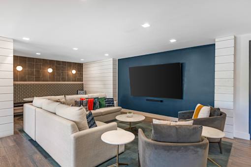 A modern living room with a grey sofa and a large television.