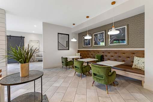 A modern dining area with green chairs and a bench.