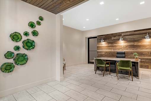 A modern dining room with a wooden wall and green chairs.