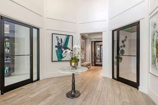 A modern interior with a glass door and a table with a plant on it.
