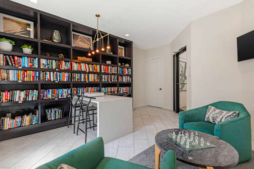 A living room with a green couch and a chess board on the coffee table.