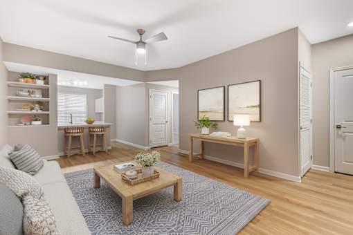 A living room with a couch, a coffee table, and a ceiling fan.