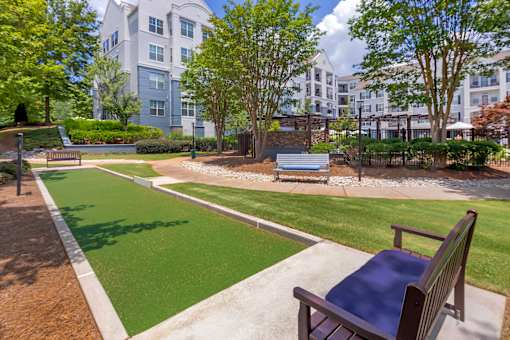 A park with a bench and a green lawn.