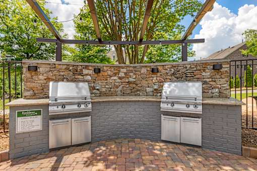 A stone wall with two grills on top.