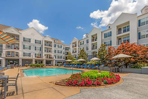 A large white building with a pool in front.