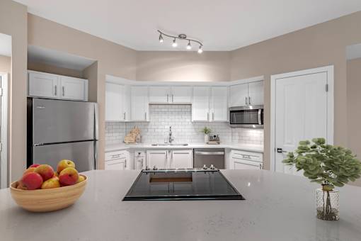 A kitchen with a bowl of fruit on the counter.