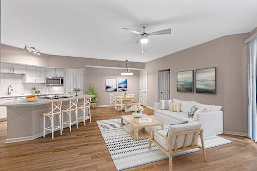 A modern kitchen with a breakfast bar and a living room with a couch.