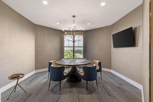 A modern dining room with a round table and chairs.