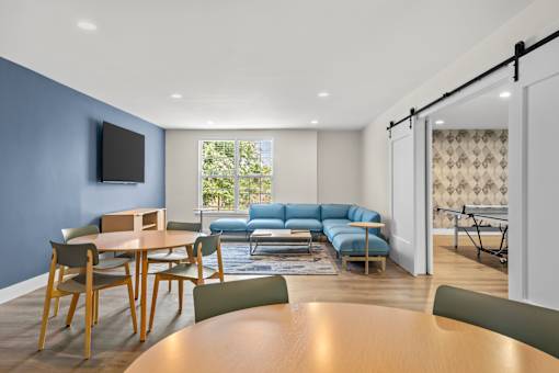 A modern living room with a blue wall and a television.