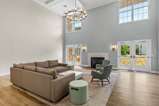 A living room with a brown couch, a green chair, and a fireplace.