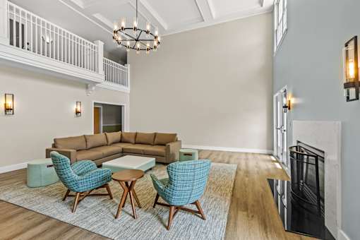 A living room with a brown couch, blue chairs, and a fireplace.