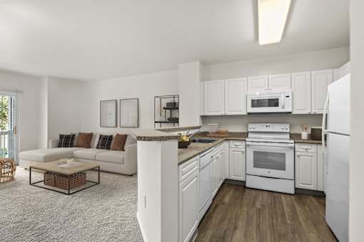 A white kitchen with a refrigerator, oven, and microwave.