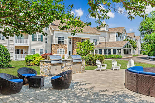 A patio with a table and chairs is surrounded by apartment buildings.