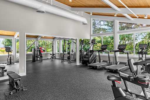 A gym with a variety of equipment including treadmills, weights, and exercise machines.