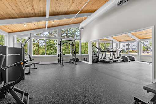 A gym with a variety of equipment including treadmills, weights, and exercise machines.