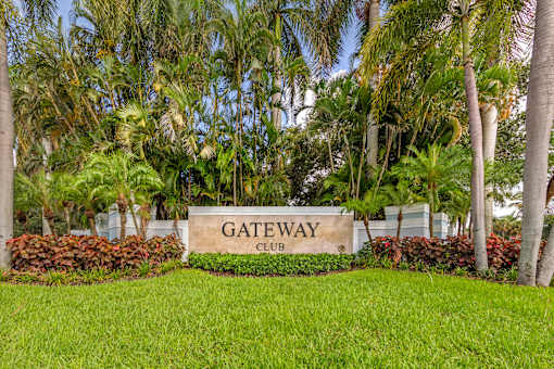 A sign that says Gateway Club in front of some trees.