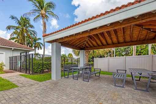 A patio with a table and chairs under a roof.