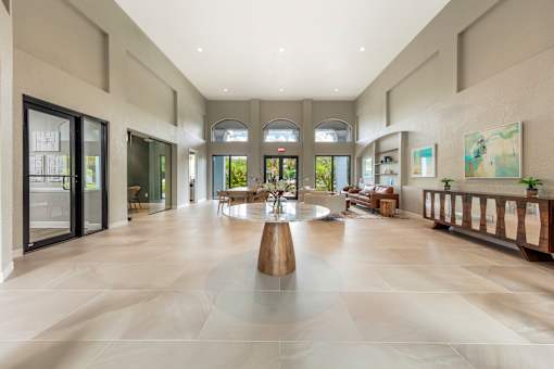 A spacious lobby with a large wooden table in the center.
