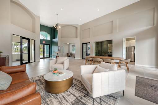 A modern living room with a white sofa and a gold coffee table.