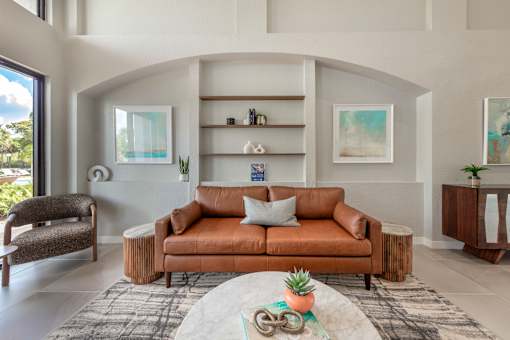 A living room with a brown couch and a rug.