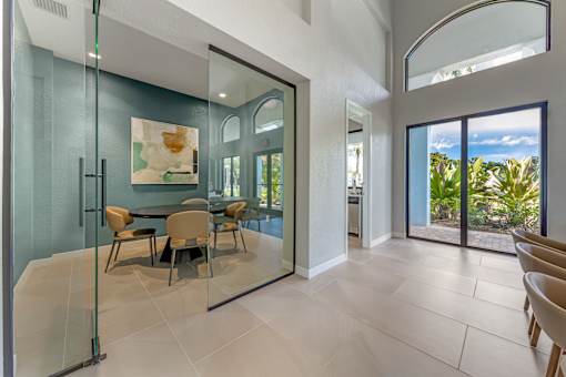 A modern dining room with a glass table and chairs.