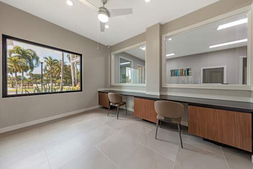 A room with a chair and a table in front of a mirror.