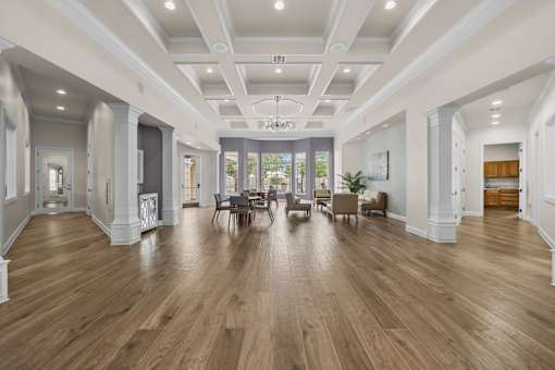 A spacious room with wooden floors and a high ceiling.