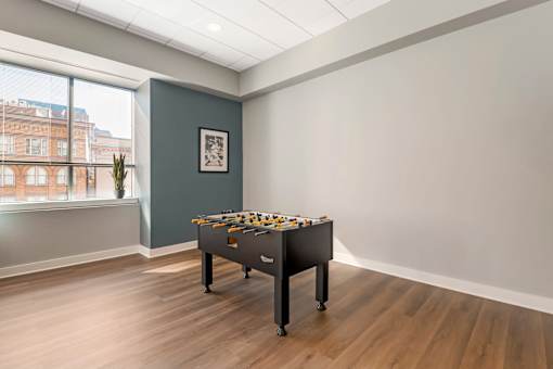 A foosball table sits in a room with a window.