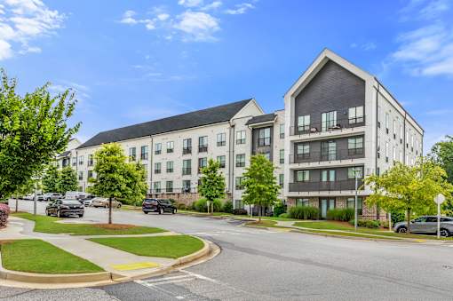 A modern apartment building with a curved driveway in front.