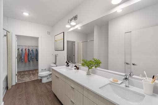 A bathroom with a white counter top and a white sink.