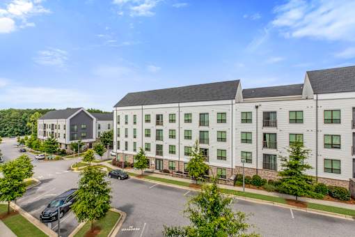 A large white building with a parking lot in front.
