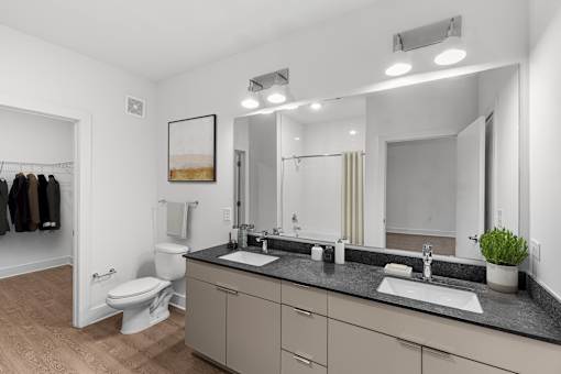 A bathroom with a toilet, sink, and mirror.