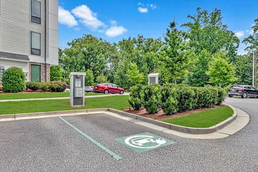 A parking lot with a green electric car charging station.