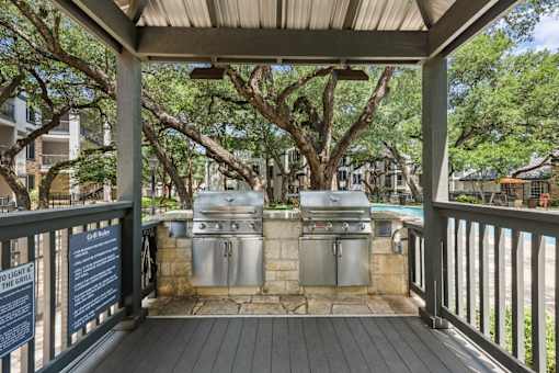 A covered outdoor area with a grill and a sign that says "Grill on Light the Grill".