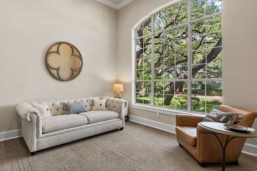 A white couch with a pillow and a round decoration on the wall.