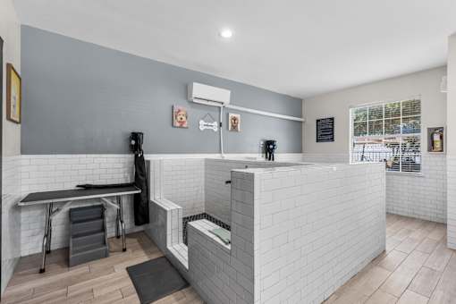 A modern kitchen with a white tiled backsplash and a black countertop.
