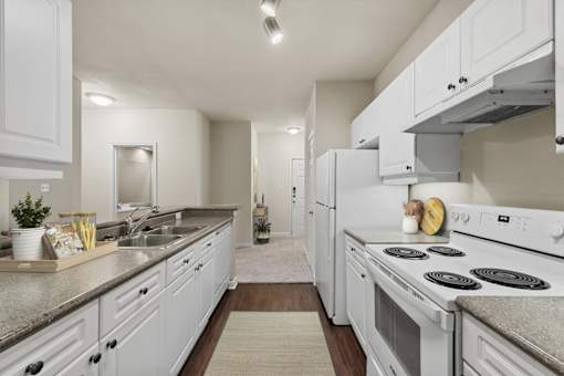 A modern kitchen with white cabinets and appliances.