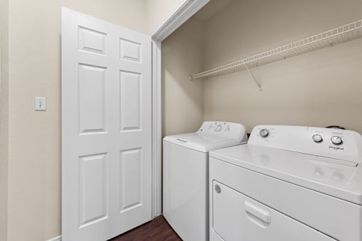 A white door is open to a laundry room with a washer and dryer.