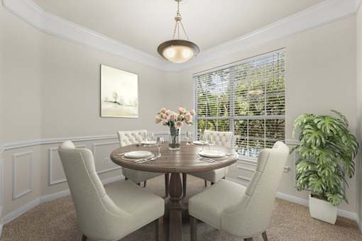 A dining room with a round table and chairs.