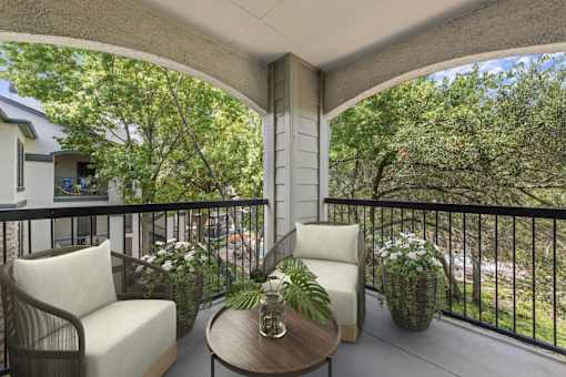 A patio with a table and chairs overlooking a street.