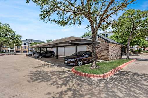 A black car is parked in a driveway.