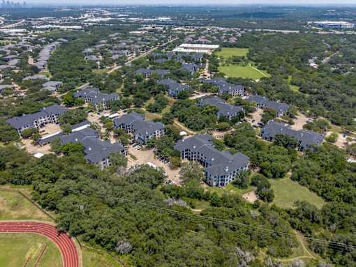 A large group of houses are surrounded by trees.