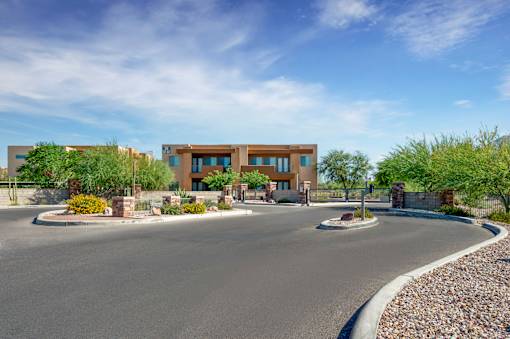 A modern building with a curved driveway in front.