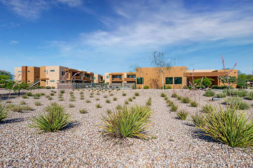 A building complex with a gravel courtyard in front.