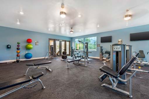 A gym with a variety of equipment including weights and exercise machines.