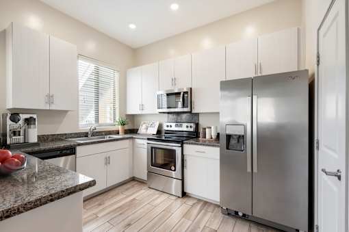 A modern kitchen with stainless steel appliances and white cabinets.