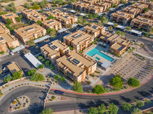 A bird's eye view of a residential area with a roundabout and a swimming pool.