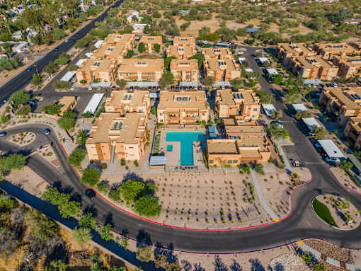 A bird's eye view of a residential area with a roundabout in the foreground.
